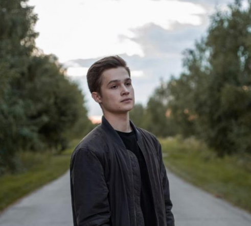 Person standing on a path with trees in the background