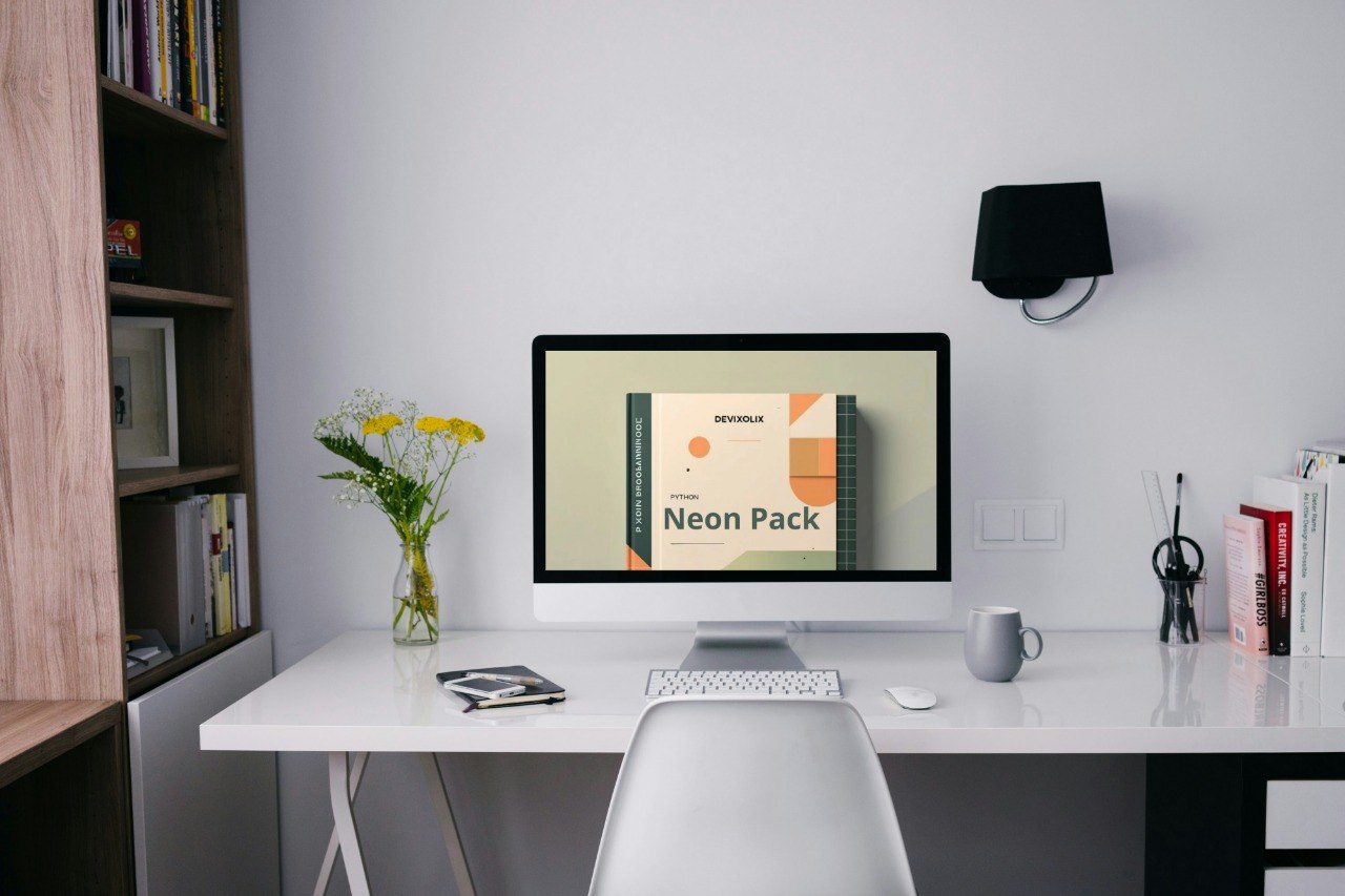 Modern office desk with computer, mug, and decor items.